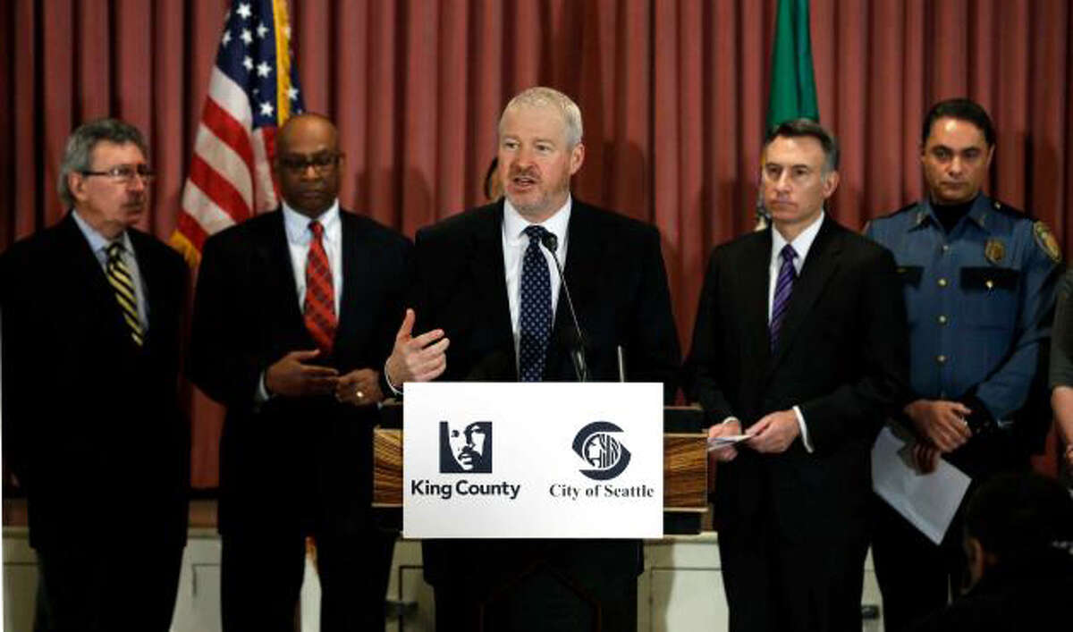 Seattle Mayor Mike McGinn, center, speaks Jan. 8, at a news conference announcing the gun buyback program. Behind him, from left, are former Seattle mayors Charles Royer, and Norm Rice, King Co. Executive Dow Constantine, and Seattle Deputy Police Chief Nick Metz. (Ted Warren/AP)
