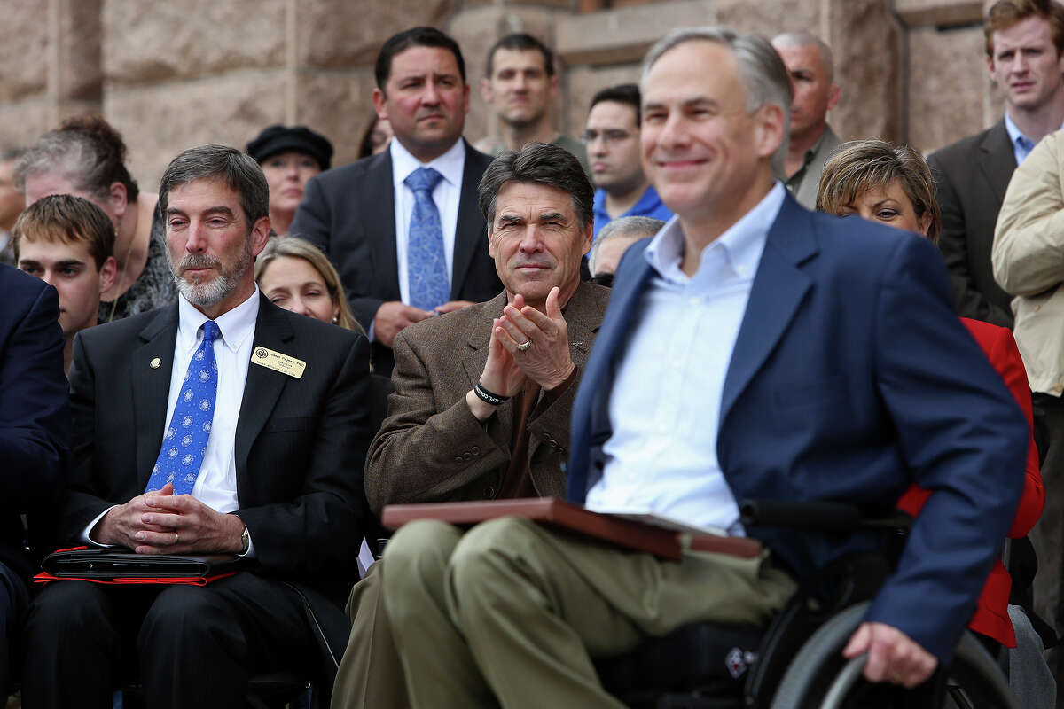 Governor Rick Perry applauds for Attorney General Greg Abbott, right, as Abbott goes to the podium to introduce Perry during the Texas Alliance for Life Rally at the Texas State Capitol in Austin on Saturday, Jan. 26, 2013. At left, is Joseph Pojman, Executive Director, Texas Alliance For Life.