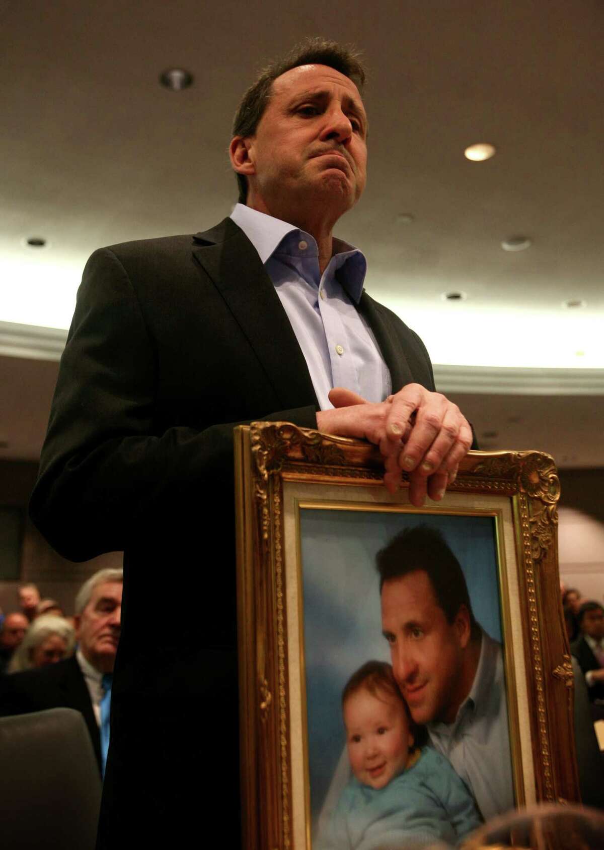 Neil Heslin, of Shelton, holds a portrait of himself and his son, Jesse Lewis, one of the children killed in the Sandy Hook School shooting, during testimony before the Gun Violence Prevention Working Group at the Legislative Office Building in Hartford on Monday, January 28, 2012.
