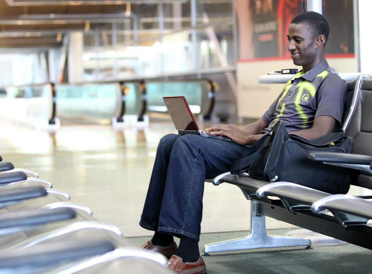 Ayo Deji Oyewo works on his laptop while waiting to catch a plane in Terminal D at the Houston Intercontinental Airport, Monday, Jan. 28, 2013, in Houston. Houston Airport System working to develop a free Wifi network at IAH and HOU airports, which are some of the last in Texas to not offer free wifi. ( Karen Warren / Houston Chronicle )
