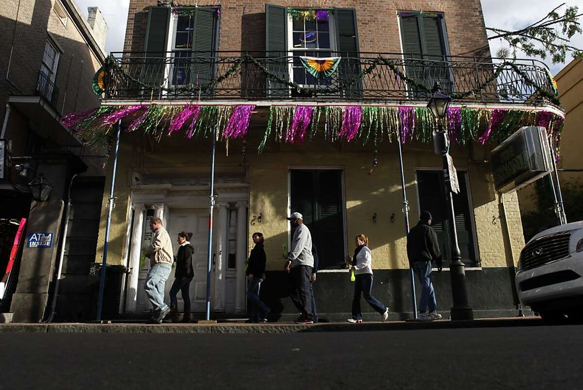 Pedestrians walks on Bourbon Street on Wednesday, January 30, 2013, in New Orleans, La. The New Orleans French Quarter, heart of the Mardi Gras celebration, is a destination for those coming for the festival and football fans who can't make it into the glitzy parties the whole week.