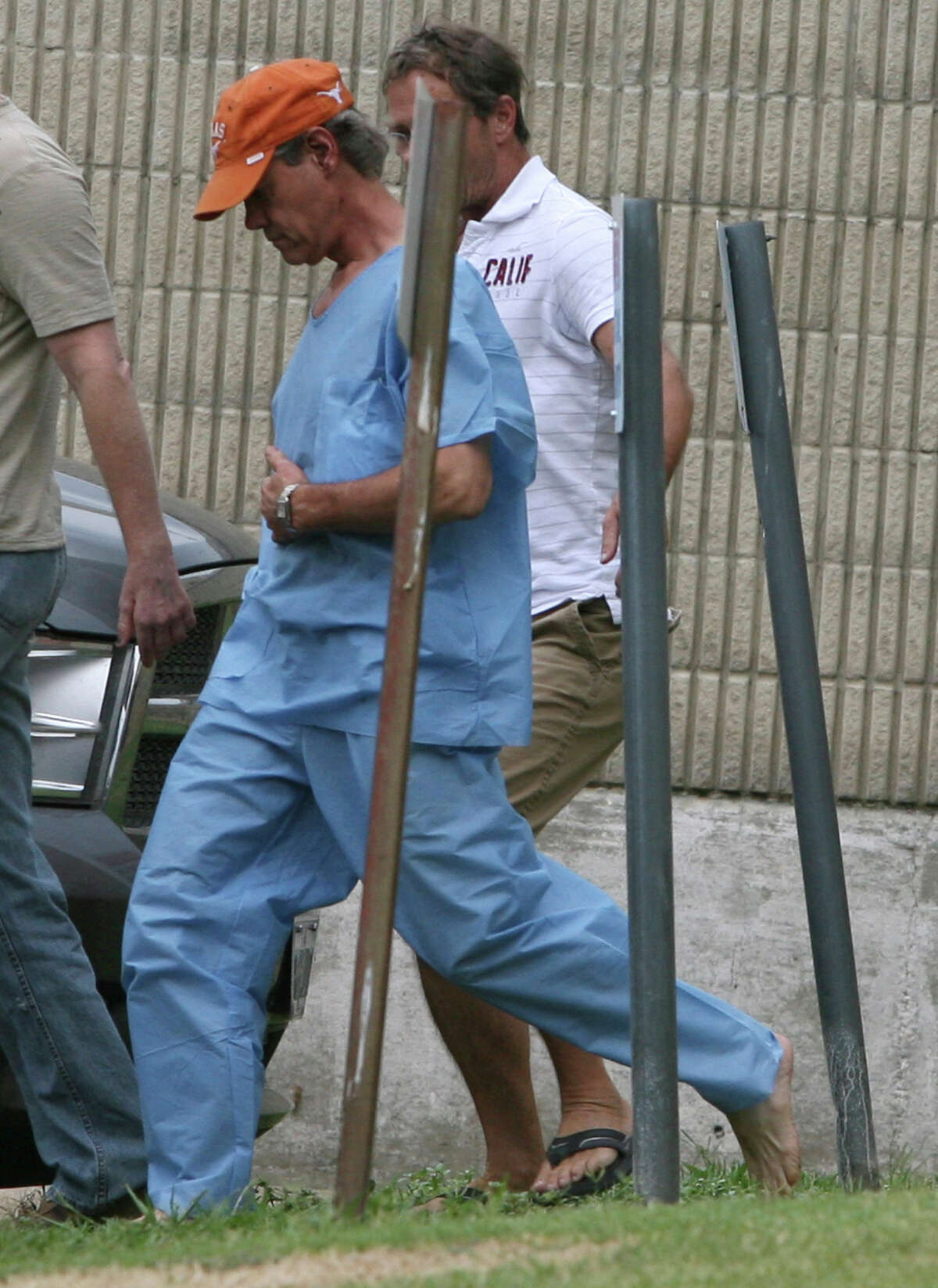 Randy Travis, center, wearing cap, exits the Grayson County jail with two unknown persons Wednesday Aug. 8, 2012, in Sherman, Texas, after being arraigned on charges of driving while intoxicated and retaliation. (AP Photo/The Herald Democrat, Chris Jennings) TV OUT; MAGS OUT; TV AND MAGAZINE CALL FOR RATES TERMS;MANDATORY CREDIT