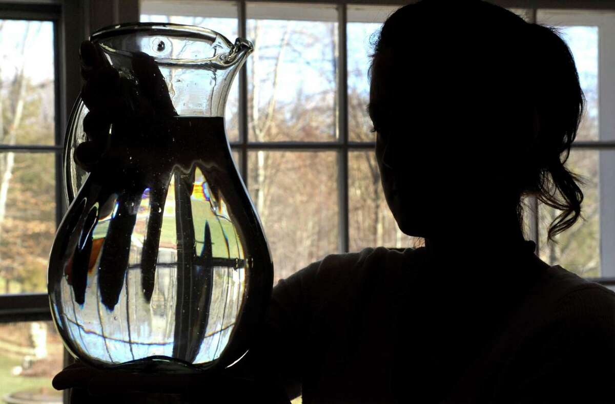 Jessica Penna holds a pitcher of water in her Weston home on Thursday, January 31, 2013. Penna's home has well-water which is contaminated with arsenic and Penna believes the arsenic has caused her health problems.