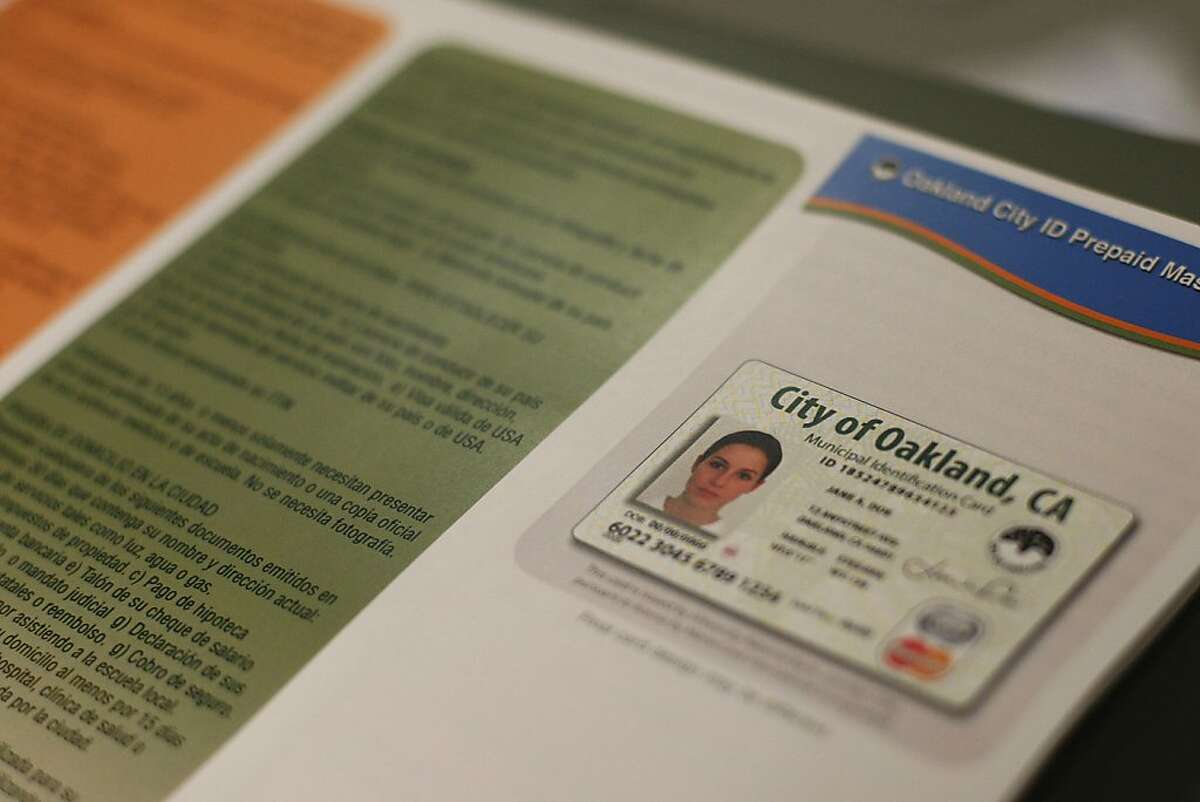 A sample of the Oakland municipal identification card is displayed on a brochure. The municipal identification doubles as a debit card and is aimed at undocumented immigrants as well as people who wish to not have their gender on the card.