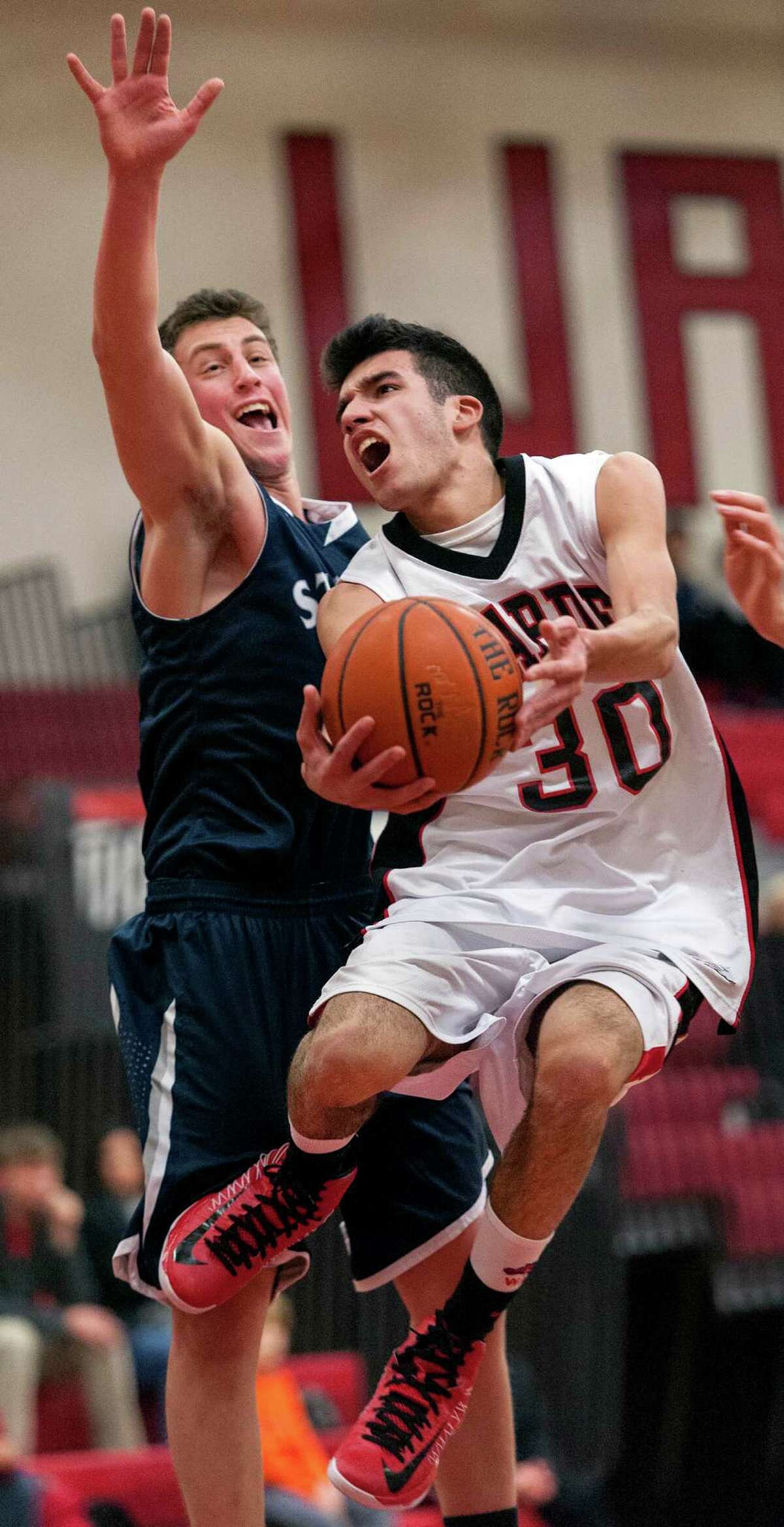 Fairfield Warde high school's Nicholas Cotto goes up for a shot as Staples high school's Todd Goldstein tries to block his shot in a boys basketball game played at Fairfield Warde high school, Fairfield, CT on Friday February 1st, 2013.