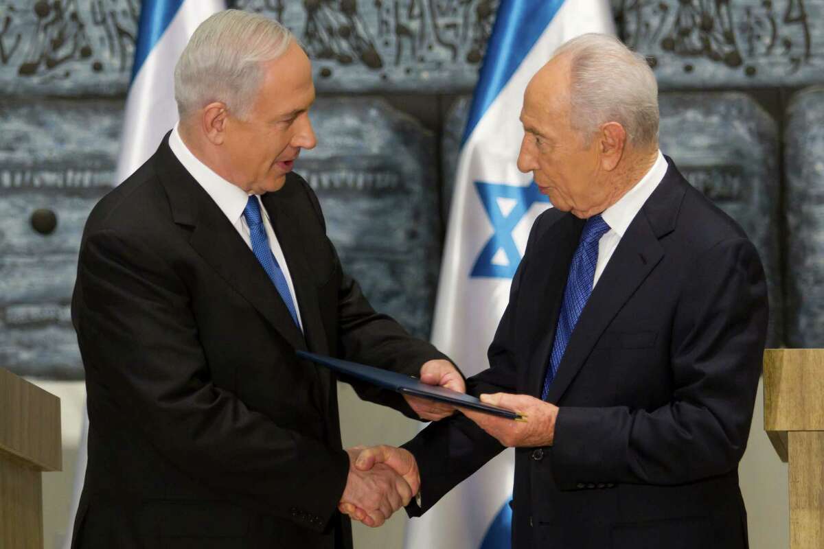 Israeli Premier Benjamin Netanyahu, left, accepts a formal request Saturday by President Simon Peres to assemble a coalition. He has six weeks to get it done.