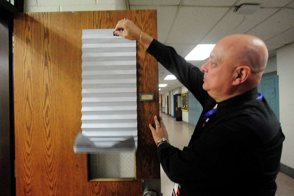 Gary Bocaccio, Danbury High School principal, inspects a new door shade like the ones that will be installed throughout the school soon, during a lockdown drill Friday, Feb. 1, 2013.