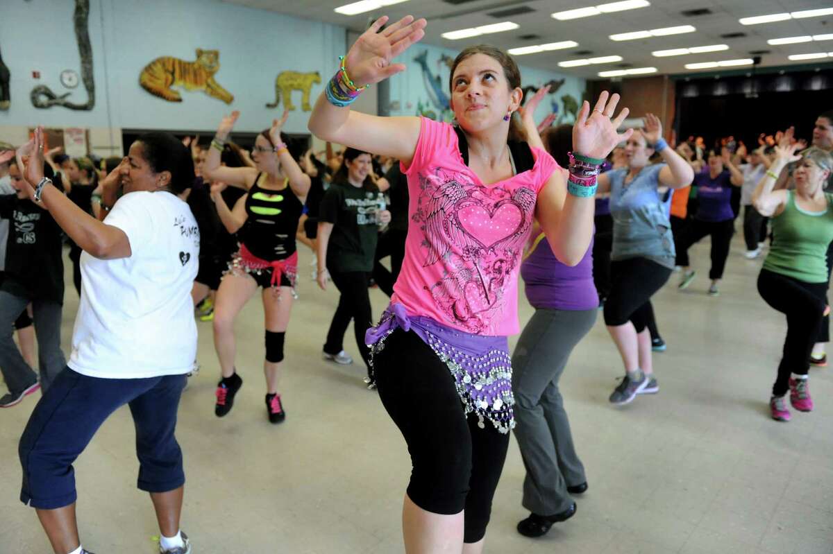 Self-proclaimed Zumbaholic, Jennifer Walker of Colonie, center, participates in a Zumbathon fundraiser in honor of Deanna Rivers and Chris Stewart on Saturday, Feb. 2, 2013, at Orenda Elementary School in Clifton Park, N.Y. Proceeds from ticket sales, raffles , baked goods and vendor sales will benefit the scholarship funds of these Shenendehowa athletes who died in a car crash. (Cindy Schultz / Times Union)