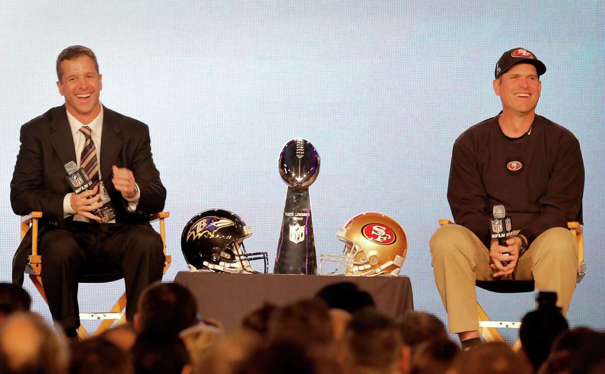 Brothers John, left, and Jim Harbaugh will become the first coaching brothers to meet in the postseason of any of the major American sports. On Sunday, they will unleash their grinding, smashmouth styles in their quests for the trophy standing between them.