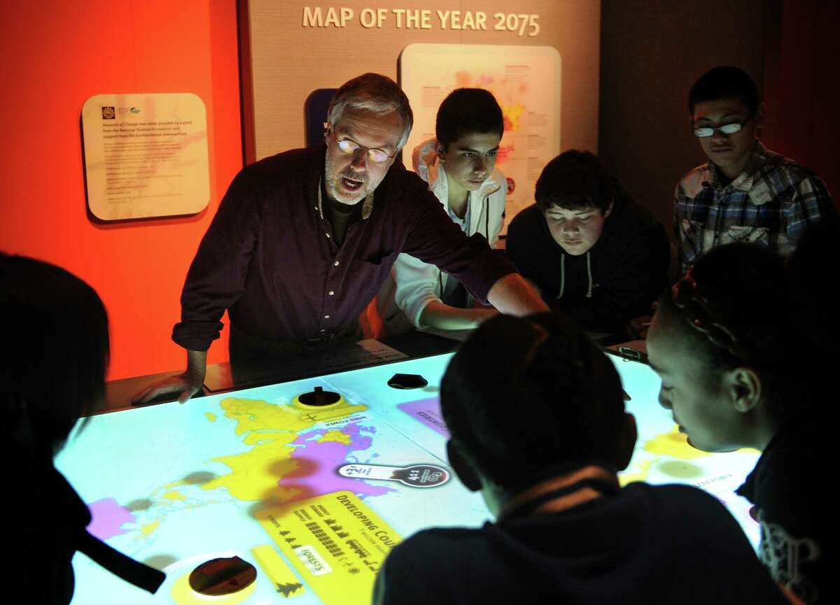 Education coordinator Jim Sirch uses an interactive map with students from New Haven's Ross Woodward Classical Studies magnet school to teach about carbon dioxide emissions in the new global warming exhibit at the Peabody Museum in New Haven on Wednesday, January 30, 2013.