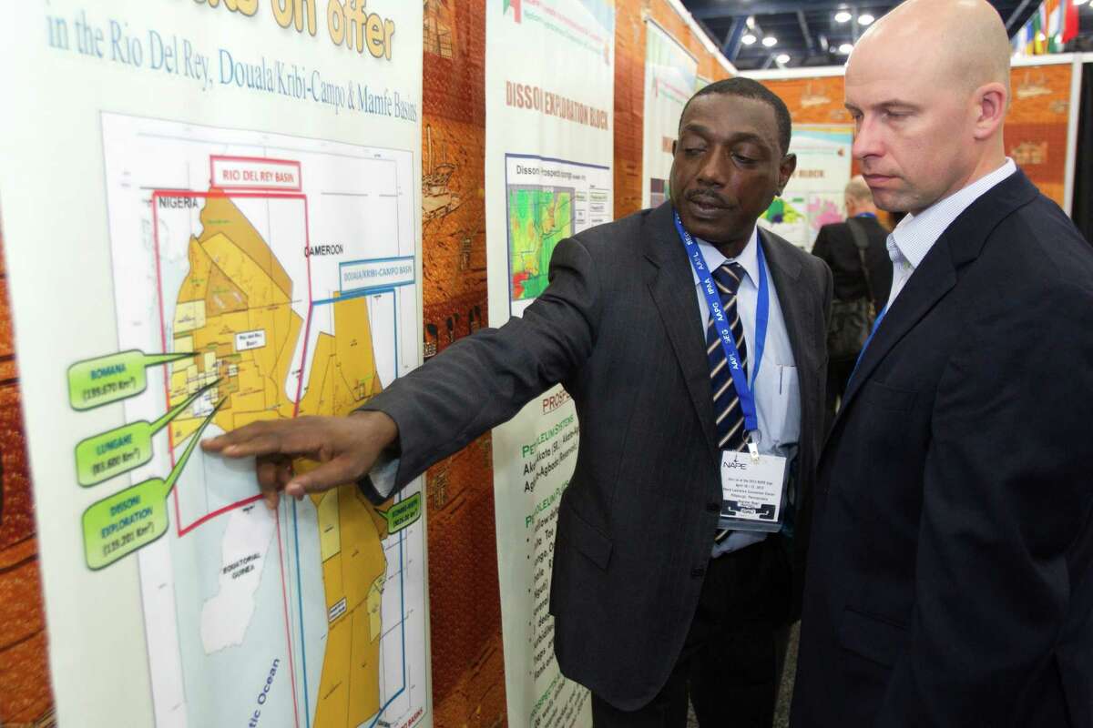 Jifon Francis, left, of the National Hydrocarbons Corporation of Camerooon, shows leasing blocks in Cameroon to Jonas Harrell, of Noble Energy, during the NAPE Expo at the George R. Brown Convention Center Tuesday, Feb. 5, 2013, in Houston.