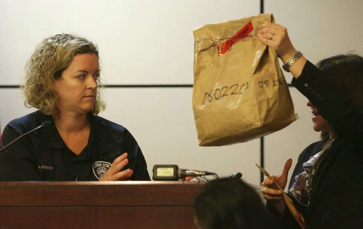 Police Department crime scene investigator Tiffany Lozano looks at an evidence bag held up by prosecutor Ana Liz De Leon-Vargas as the trial gets under way.