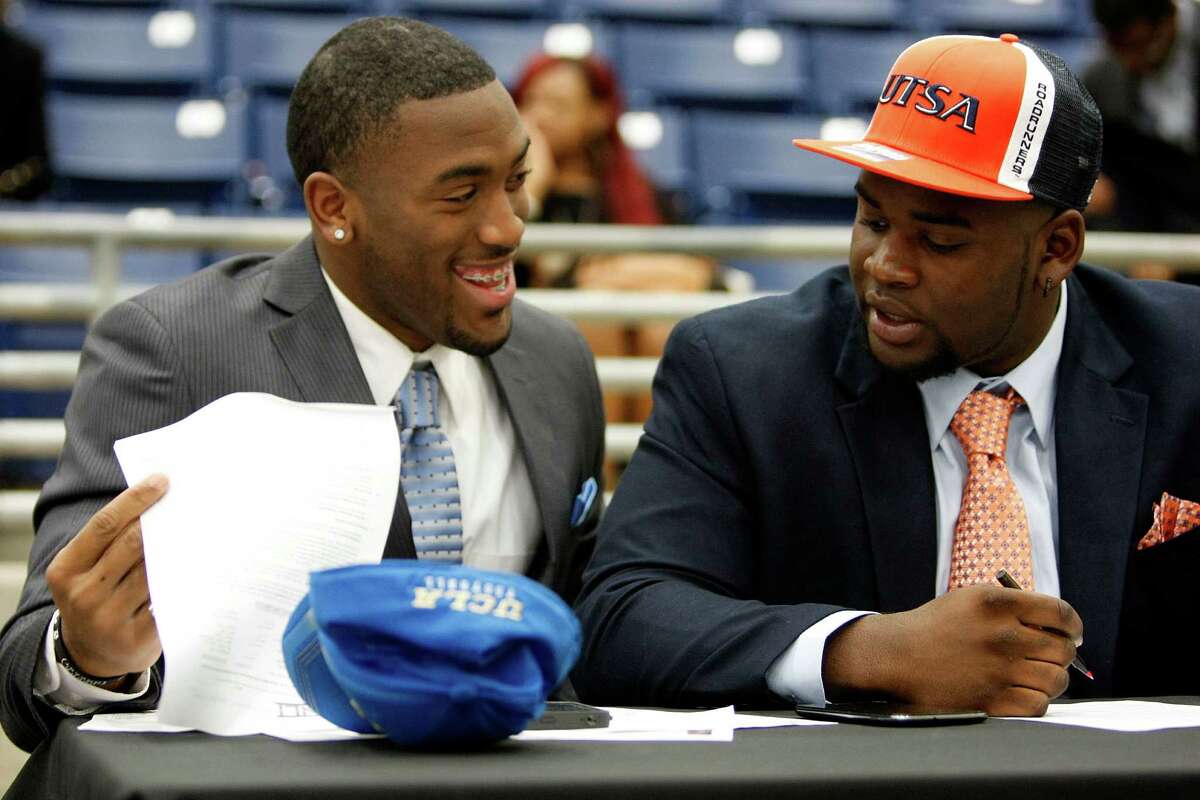 Fort Bend Marshall linebacker Deon Hollins Jr., left, who committed to play football at UCLA, shares a laugh with teammate Anthony Lee who committed to the University of Texas San Antonio during a signing day ceremony at the Buddy Hopson Field House Tuesday, Feb. 5, 2013, in Missouri City.
