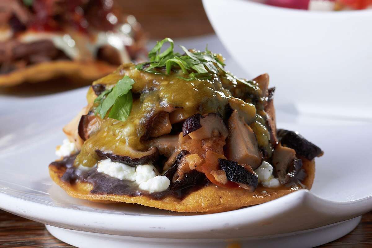 The mushroom tostada also features goat cheese, a purée of refried beans-black beans and oven-roasted tomatoes for an explosion of flavors.