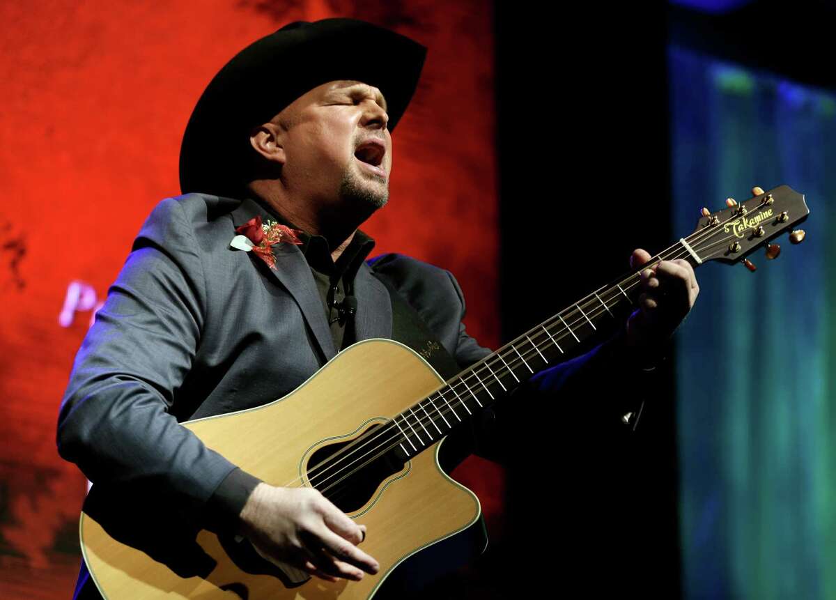 FILE - This Oct. 7, 2012 photo shows Garth Brooks singing "Papa Loved Mama," a song written by Kim Williams, as Williams is inducted into the Nashville Songwriters Hall of Fame in Nashville, Tenn. On Sunday, Oct. 21, Brooks will be inducted into the Country Music Hall of Fame. (AP Photo/Mark Humphrey, file)