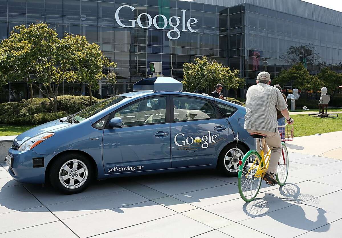 A bicyclist rides by a Google self-driving car at the Google headquarters on September 25, 2012 in Mountain View, California. California Gov. Jerry Brown signed State Senate Bill 1298 that allows driverless cars to operate on public roads for testing purposes. The bill also calls for the Department of Motor Vehicles to adopt regulations that govern licensing, bonding, testing and operation of the driverless vehicles before January 2015. (Photo by Justin Sullivan/Getty Images)