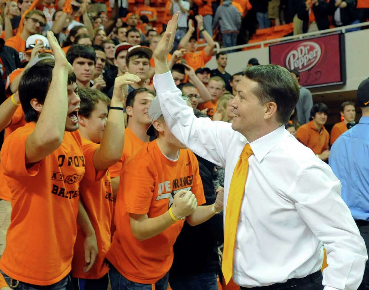 Coach Travis Ford joins the student section to celebrate Oklahoma State's last-second win over Baylor.