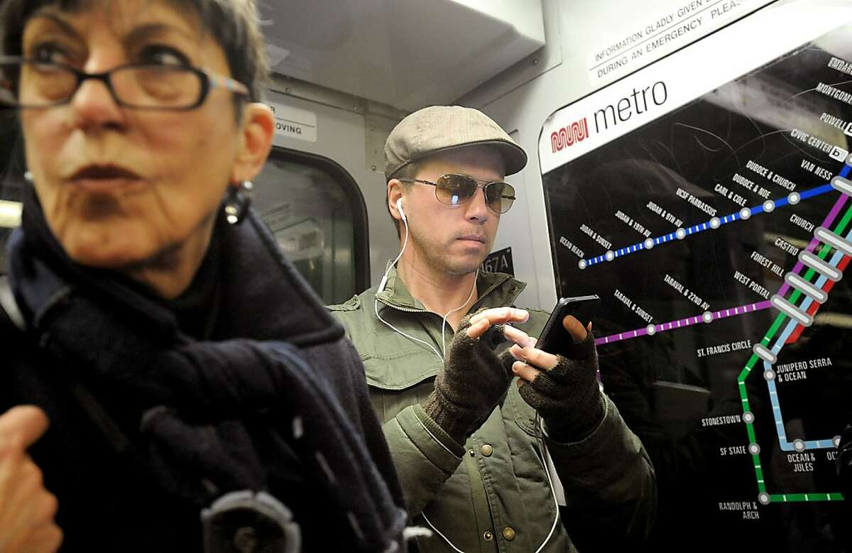Peter Campbell checks his phone while riding Muni on Thursday, Feb. 7, 2013, in San Francisco.
