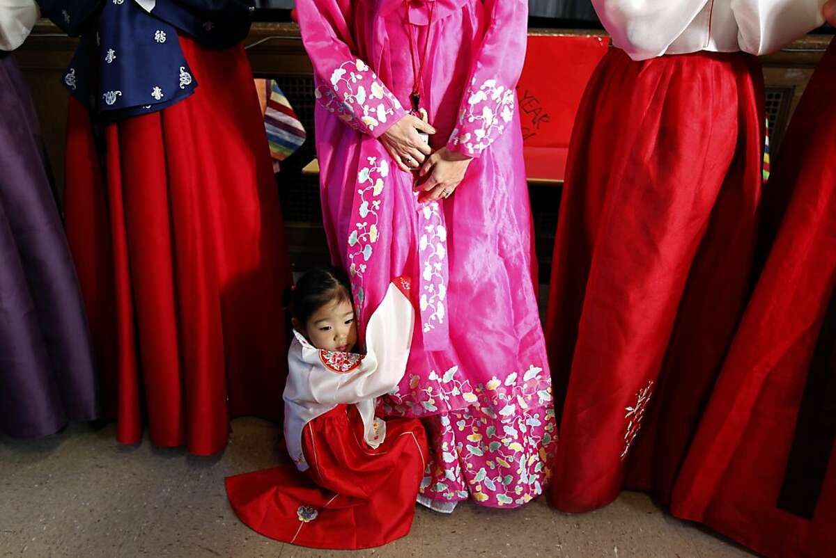 Three-year-old Zoe Chung clings to her mother, 2nd grade teacher Lissa Kim, during a celebration for Seol Nal, the Korean Lunar New Year, at Claire Lilienthal School in San Francisco, Calif. on Friday, Feb. 8, 2013. Students in the Korean-immersion program wore traditional hanbok outfits and participated in a variety of activities to celebrate the lunar new year, which begins Sunday.