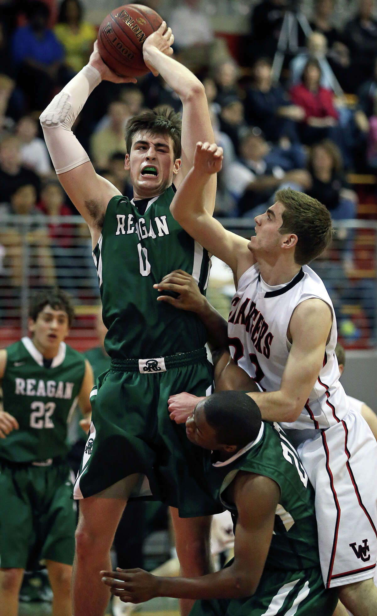 Rattler center D.J. MacLeay rips a rebound away from Sam Burmeister as Reagan plays Churchill at the Lee High School gym on February 8, 2013.