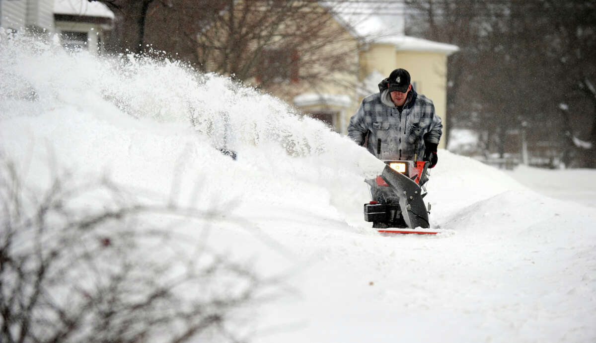 Brandon Hyde, 32, uses a snowblower to clear the sidewalk near his home on Roberts Ave. in Danbury, Conn. Saturday morning, February 9, 2013. A blizzard dumped almost two feet of snow in the Danbury area Friday and Saturday.