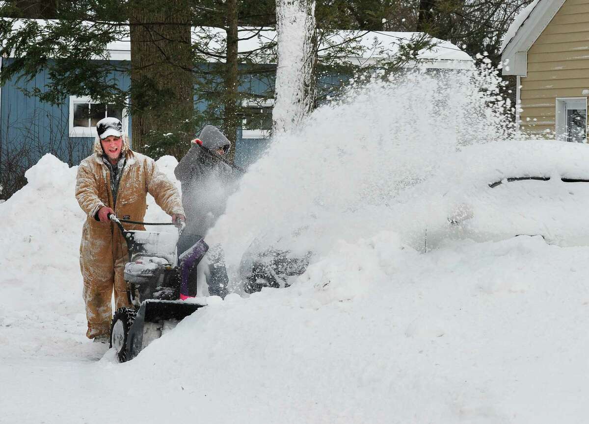 Brian Rosler uses his snowblower to help a neighbor dig out of the snow in Danbury Saturday, Feb. 9, 2013.