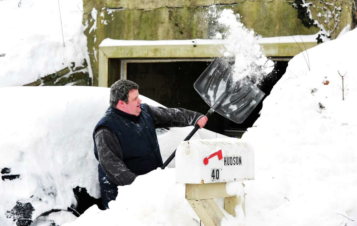 Joe Hudson digs his car out of the snow in Danbury Saturday, Feb. 9, 2013.