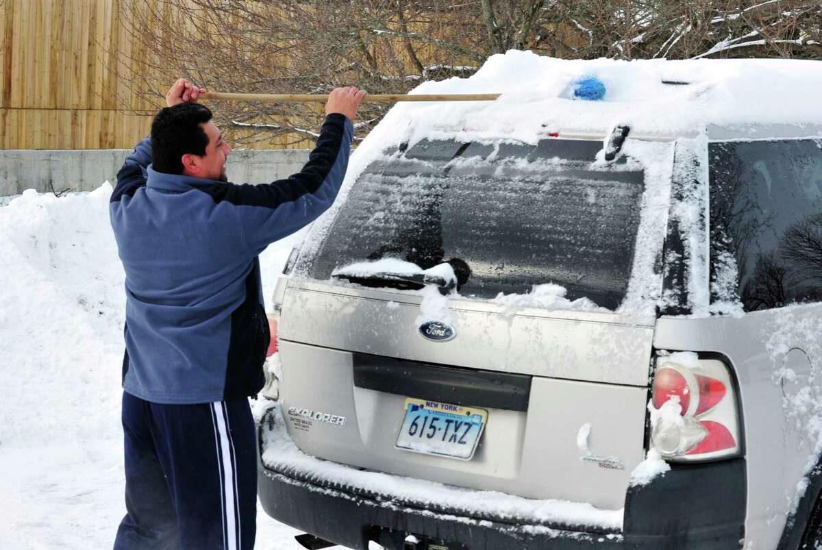 Antonio Vtrera clears snow off his car roof in Danbury Saturday, Feb. 9, 2013.