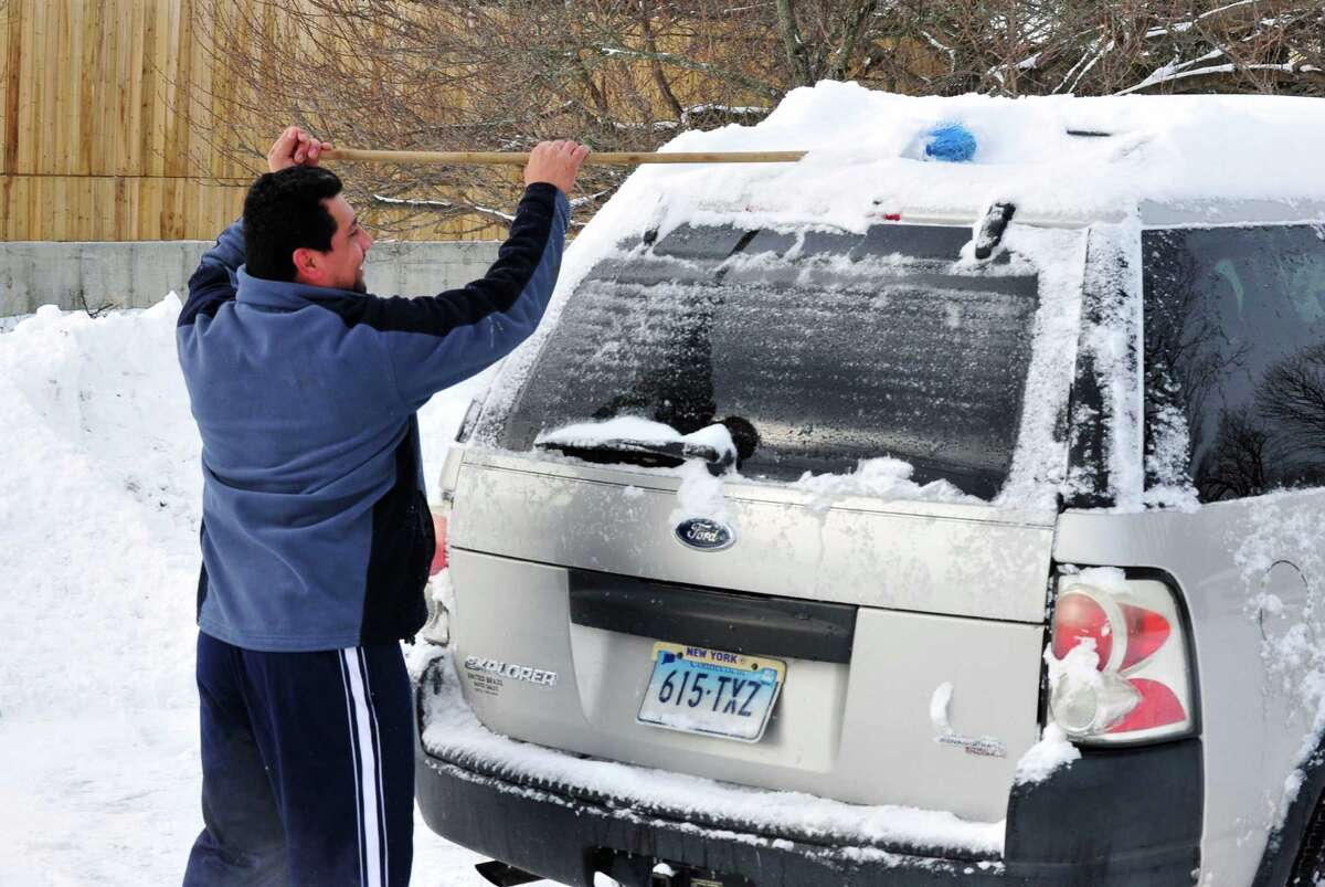 Antonio Vtrera clears snow off his car roof in Danbury Saturday, Feb. 9, 2013.