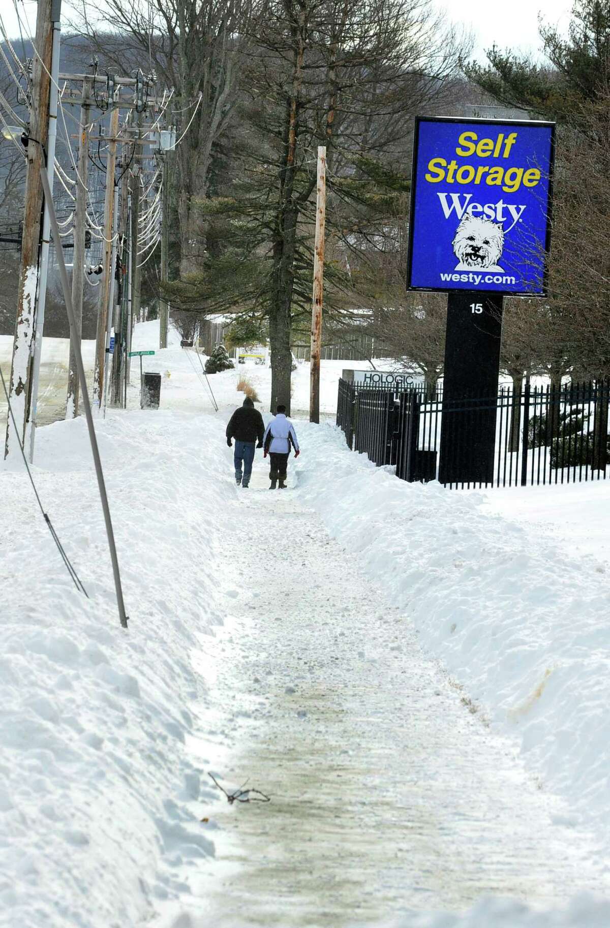 A couple walk in the snow along Kenosia Avenue in Danbury Saturday, Feb. 9, 2013.