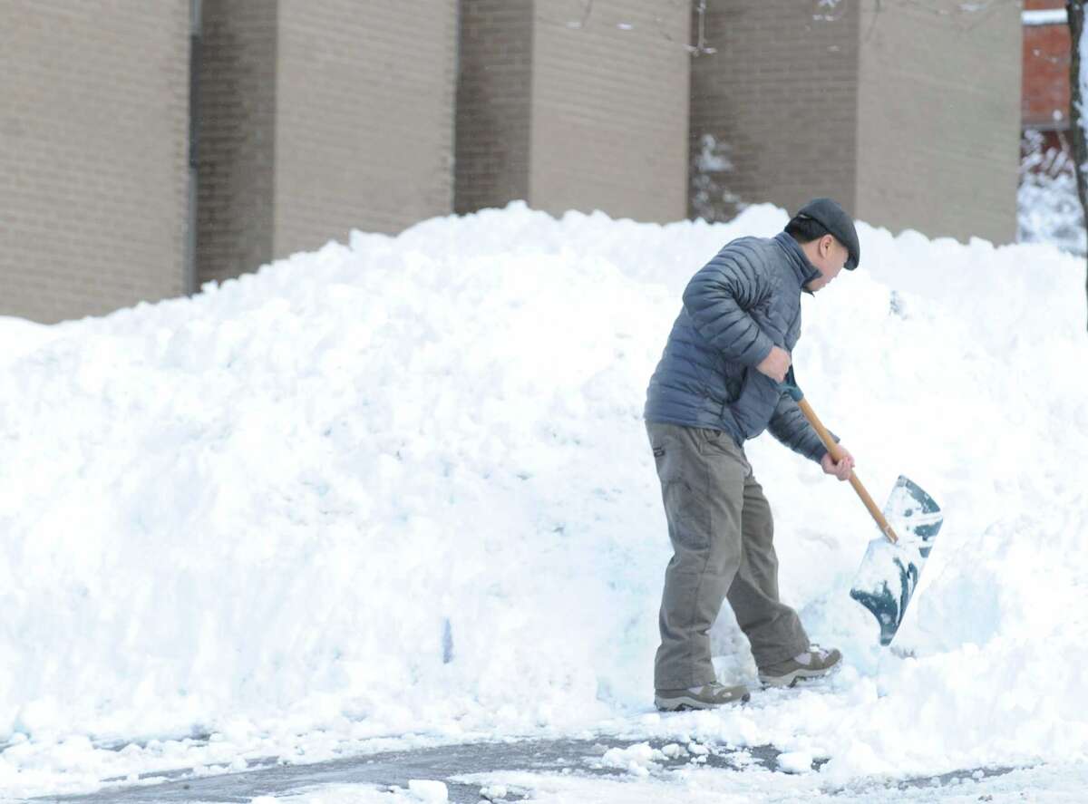A man who said his name was Paul, clears snow from in front of a West Putnam Avenue business during the aftermath of the blizzard that hit Greenwich, Conn., Saturday morning, Feb. 9, 2013.