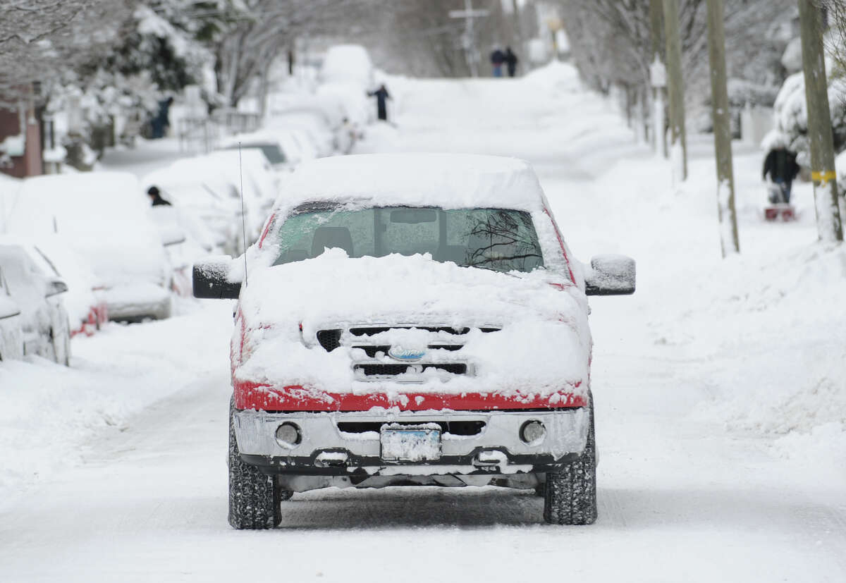 A truck covered in snow navigates a snowy South Water Street during the aftermath of the blizzard that hit Greenwich, Conn., Saturday morning, Feb. 9, 2013.