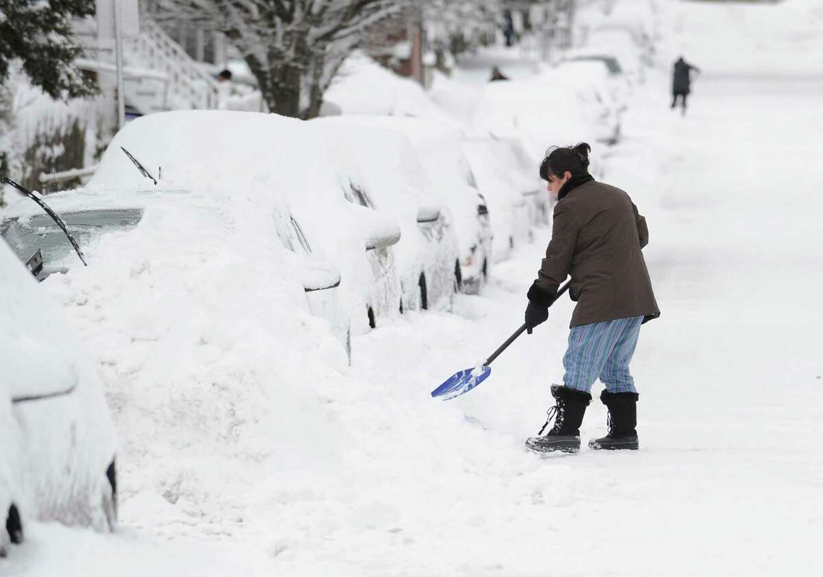 Tina Khoshaboo clears snow from her car on South Water Street in Byram during the aftermath of the blizzard that hit Greenwich, Conn., Saturday morning, Feb. 9, 2013.