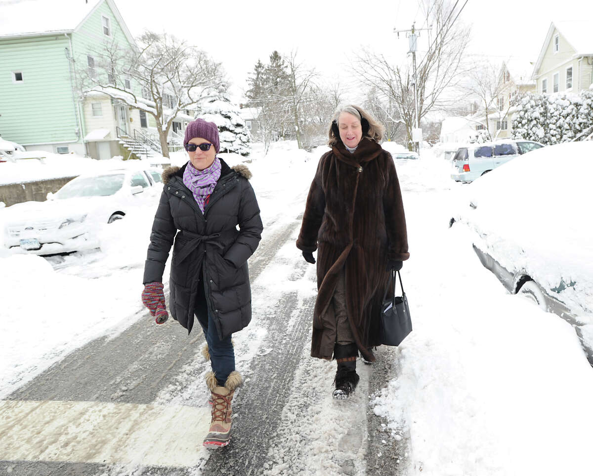 Dana Myers, left, and Kathy Anderson, both of Byram, walk on Mead Avenue during the aftermath of the blizzard that hit Greenwich, Conn., Saturday morning, Feb. 9, 2013.