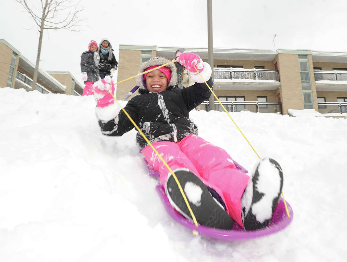 Paige Pray, 8, enjoys riding her sled in the snow at the Armstrong Court Public Housing Complex during the aftermath of the blizzard that hit Greenwich, Conn., Saturday morning, Feb. 9, 2013.