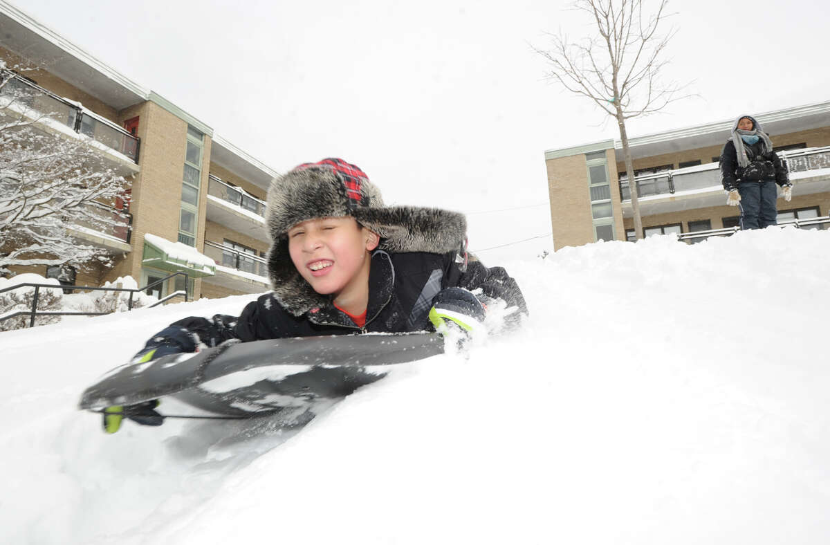 Daniel Estrella, 9, enjoys a sled ride during the aftermath of the blizzard at the Armstrong Court Public Housing Complex, Greenwich, Conn., Saturday morning, Feb. 9, 2013.