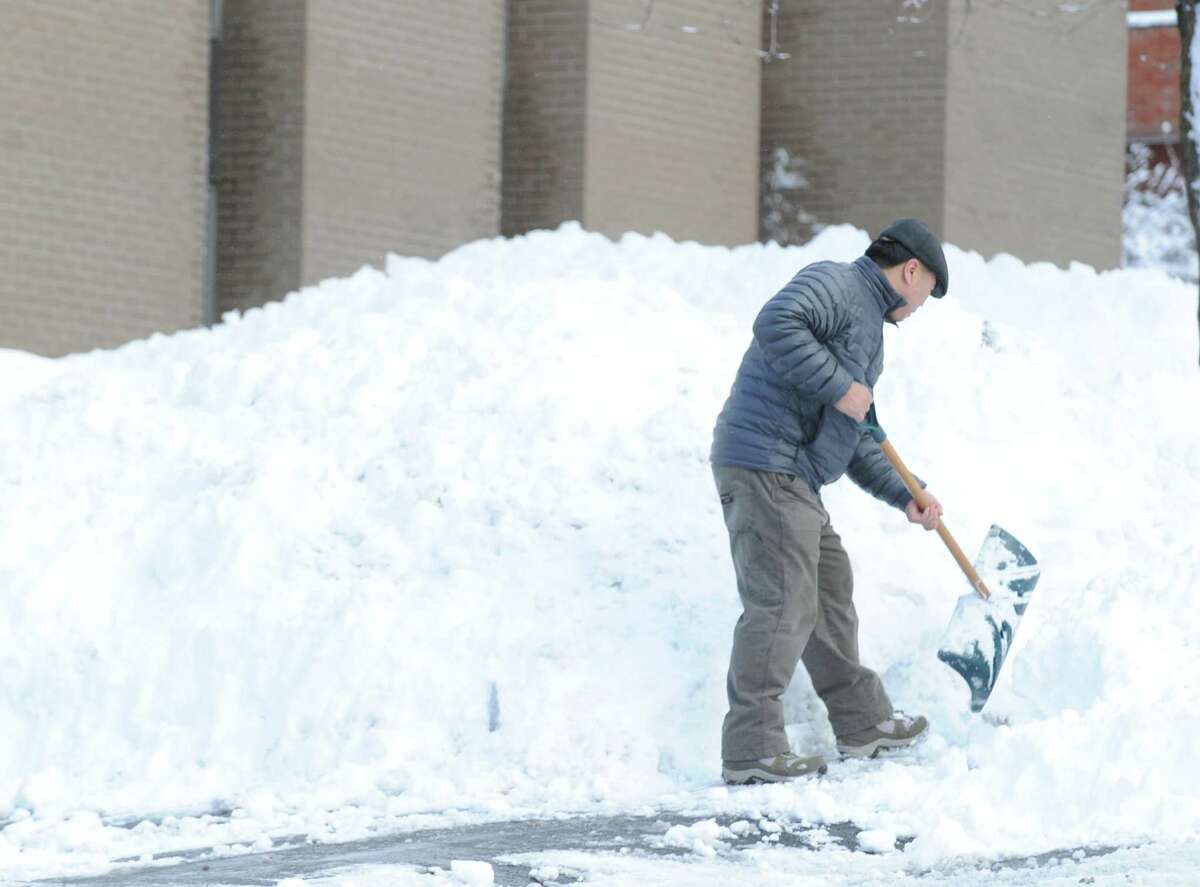 A man who said his name was Paul, clears snow from in front of a West Putnam Avenue business during the aftermath of the blizzard that hit Greenwich, Conn., Saturday morning, Feb. 9, 2013.