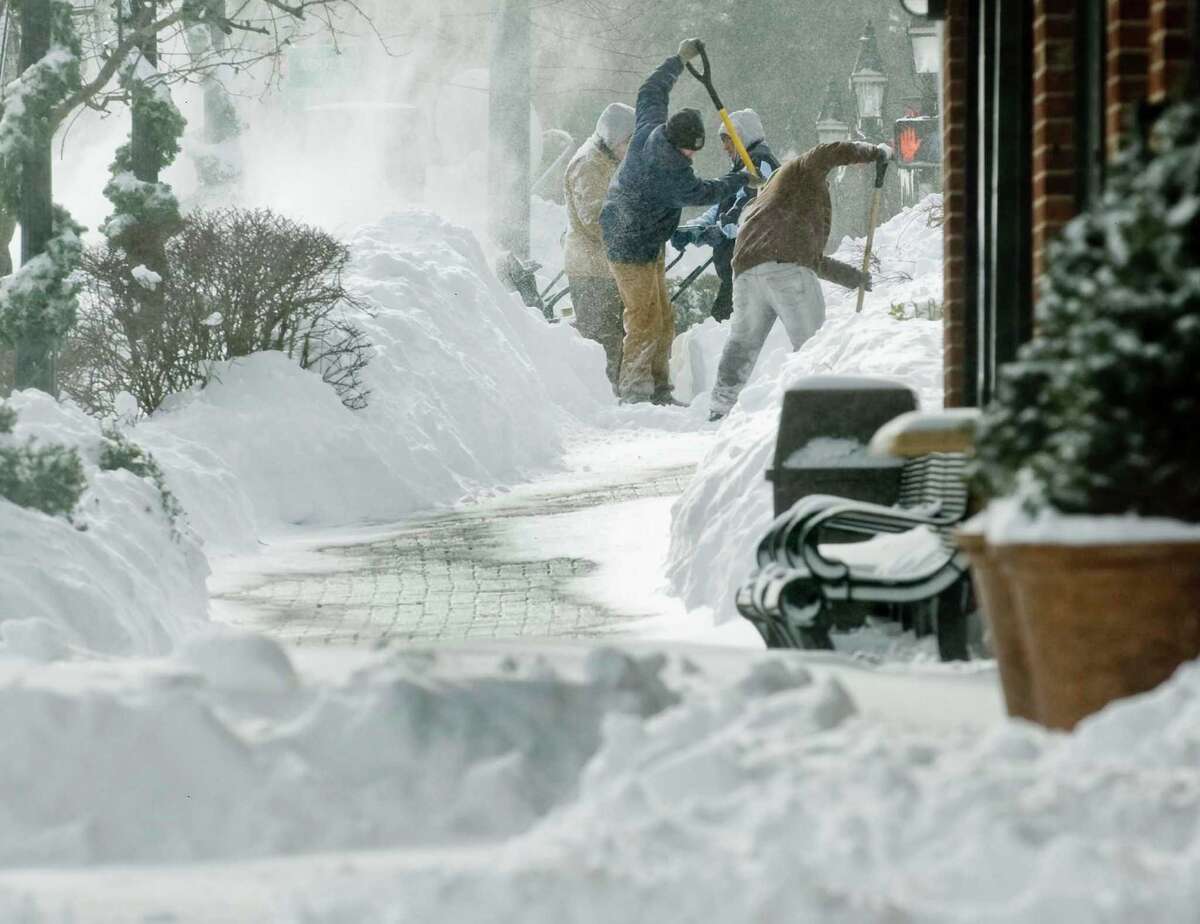 Workers shovel a sidewalk frantically in blowing snow on Main Street in Ridgefield after the snowstorm. Saturday, Feb. 9, 2013