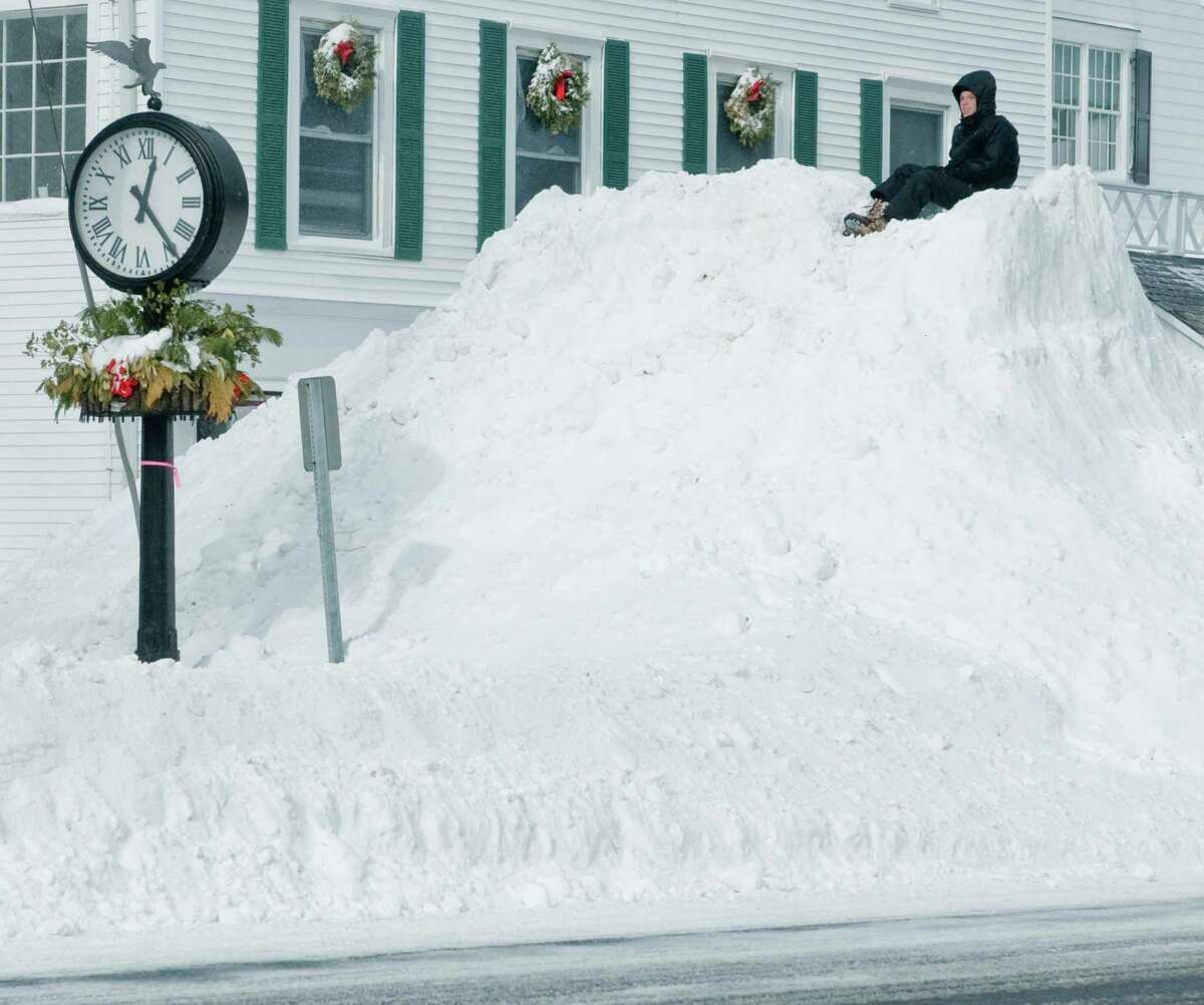 Gabe Altopp, 15 of Ridgefield, sits on top of a plowed pile of snow on Main Street in Ridgefield after the snowstorm had passed. Saturday, Feb. 9, 2013