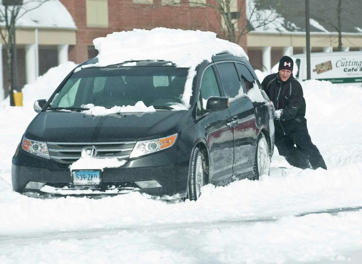 Rick Matte of Ridgefield tries to push his car after getting stuck in the Kohl's parking lot in Ridgefield. Saturday, Feb. 9, 2013