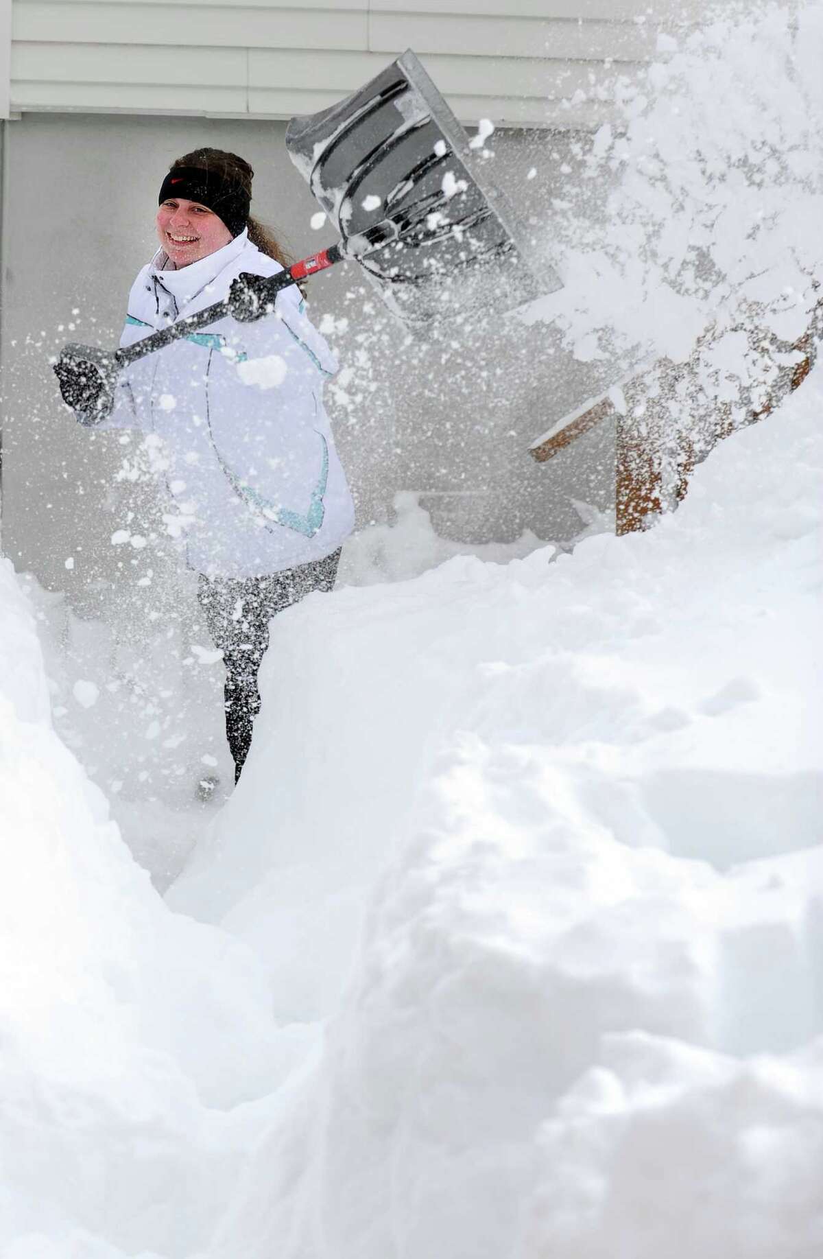 Tania Tchir shovels a path from her house in Derby, Conn. as residents face massive snow removal Saturday, Feb. 9, 2013 following a severe blizzard that dumped up to three feet of snow across the state.