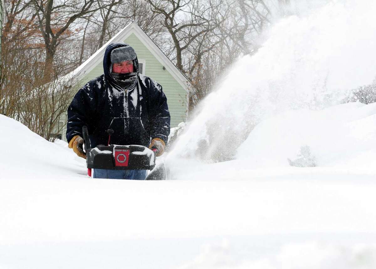 Moises Diaz uses a snowblower to clear his driveway in Derby, Conn. as residents face massive snow removal Saturday, Feb. 9, 2013 following a severe blizzard that dumped up to three feet of snow across the state.