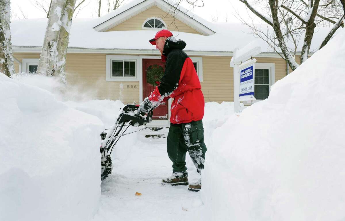 Ryan Adams uses a snowblower to clear the sidewalk in front of his home in Derby, Conn. Saturday, Feb. 9, 2013 following a severe blizzard that dumped up to three feet of snow across the state.