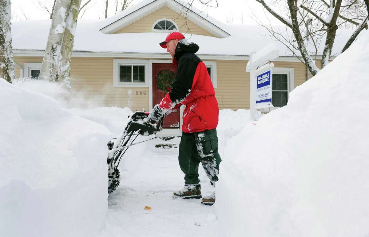 Ryan Adams uses a snowblower to clear the sidewalk in front of his home in Derby, Conn. Saturday, Feb. 9, 2013 following a severe blizzard that dumped up to three feet of snow across the state.