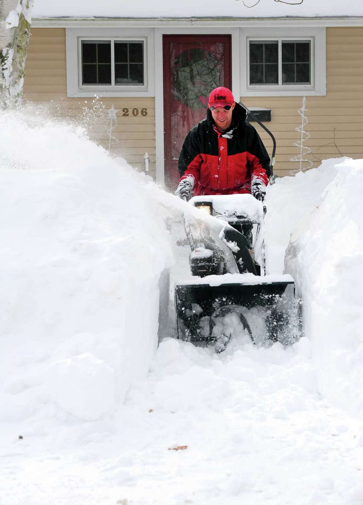 Ryan Adams uses a snowblower to clear the sidewalk in front of his home in Derby, Conn. Saturday, Feb. 9, 2013 following a severe blizzard that dumped up to three feet of snow across the state.