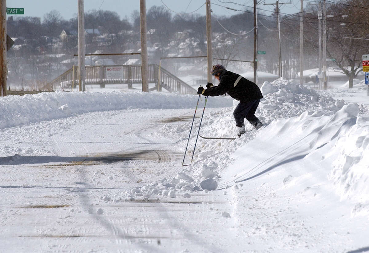 A cross country skier works her way over a snow bank onto Beach Street after a blizzard pounded the region in West Haven, Conn. on Saturday February 9, 2013.