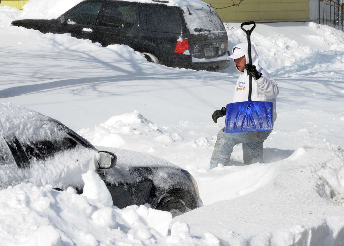 Tito Santana trudges his way across the street to help a neighbor shovel out after a blizzard pounded the region in West Haven, Conn. on Saturday February 9, 2013.