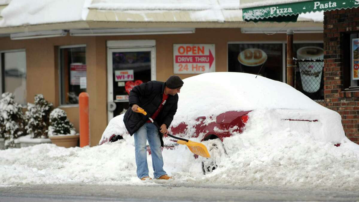 A man digs out his car in Stamford, Conn., on Saturday, February 9, 2013.