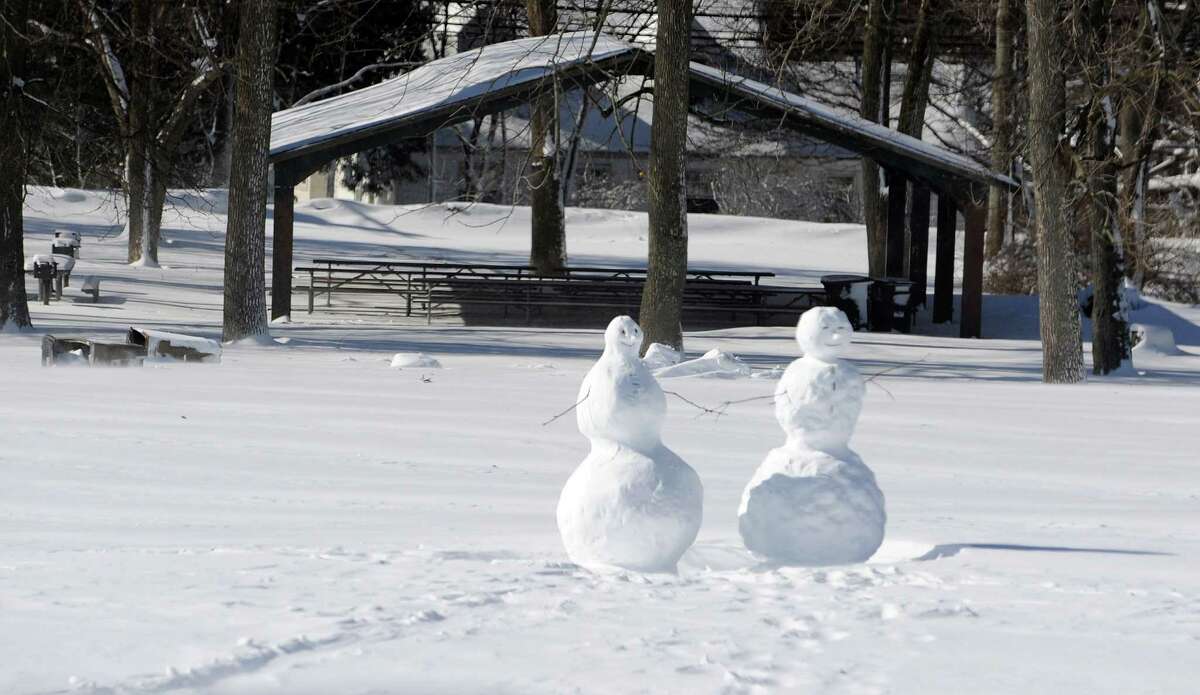 Snowmen sit constructed in Stamford, Conn., on Saturday, February 9, 2013.