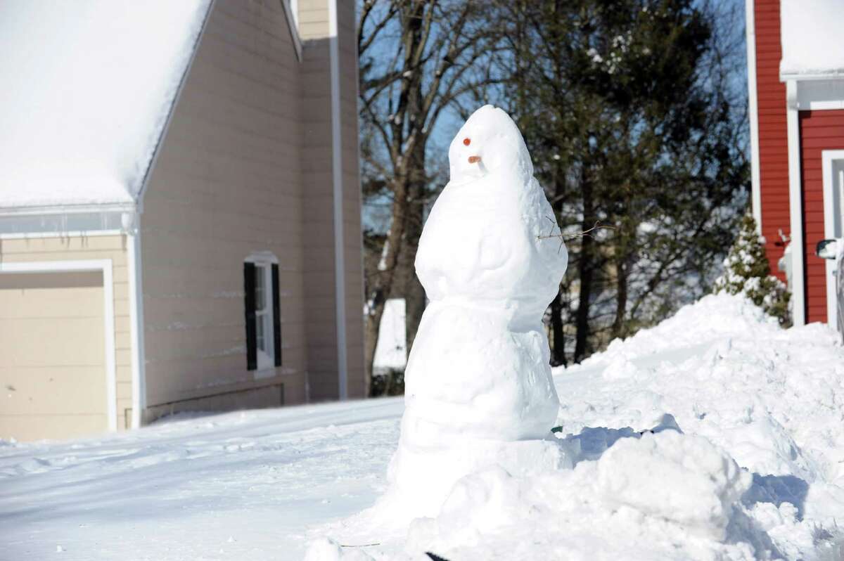 Snowmen sit constructed in Stamford, Conn., on Saturday, February 9, 2013.